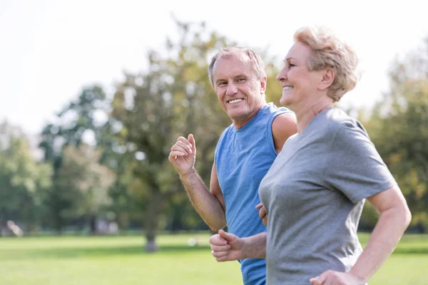 Feliz Homem Sênior Olhando Para Mulher Enquanto Jogging Parque — Fotografia de Stock