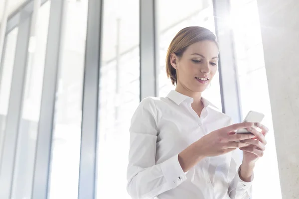 Empresaria Usando Teléfono Móvil Mientras Está Pie Oficina — Foto de Stock