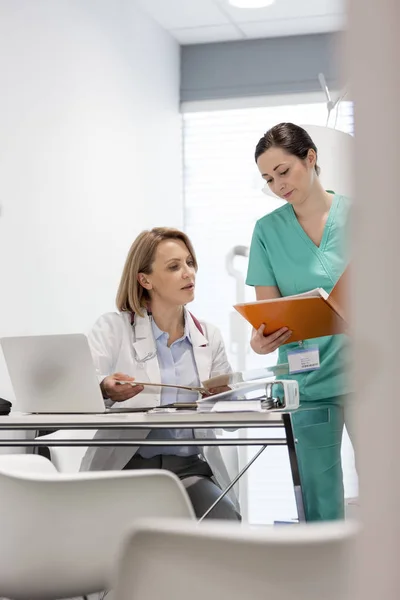 Infermiera Che Mostra Cartella Clinica Medico Maturo Alla Scrivania Ospedale — Foto Stock