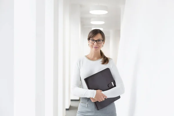 Portret Pewnej Siebie Bizneswoman Stojącej Dokumentem Korytarzu Biurze — Zdjęcie stockowe