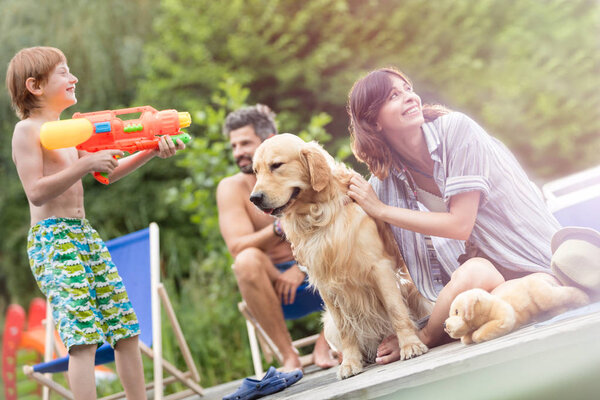 Наклонный снимок семьи с золотистым ретривером на пирсе
