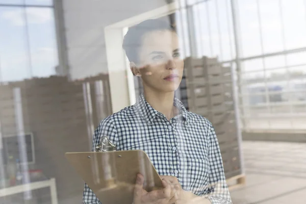 Nachdenklicher Bauer Mit Klemmbrett Gegen Kisten Durch Fenster Verteilerhaus Gesehen — Stockfoto