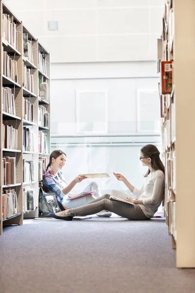 Estudantes Passando Livro Enquanto Sentado Biblioteca Universidade — Fotografia de Stock