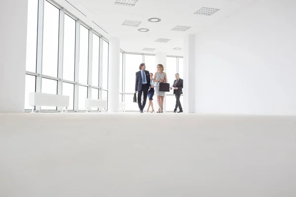 Full Length Colleagues Talking While Walking Corridor Office — Stock Photo, Image