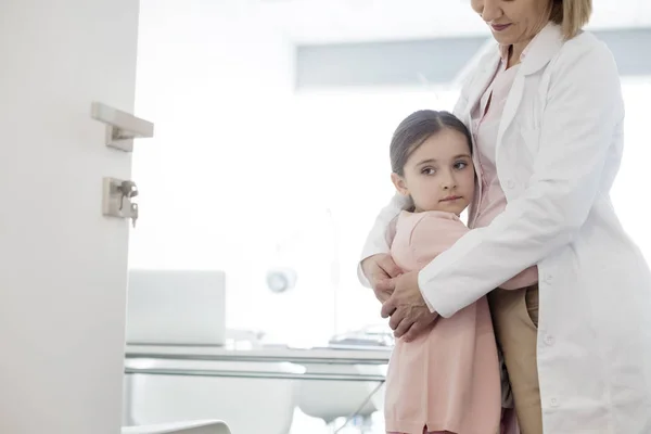Arzt Umarmt Kleine Patientin Vor Offener Tür Krankenhaus — Stockfoto