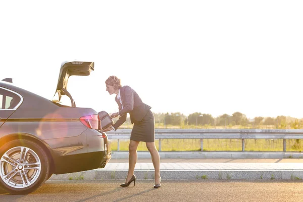 Mature Businesswoman Removing Suitcase Car Trunk Road Sky — Stock Photo, Image