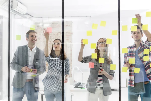 Självsäker Kollegor Klibba Noterar Glasvägg Office — Stockfoto