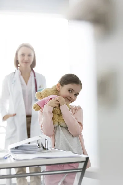 Portrait Une Fille Souriante Avec Ours Peluche Debout Contre Médecin — Photo