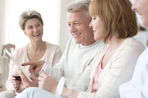 Smiling Mature Man Showing Digital Tablet Friends Home — Stock Photo, Image