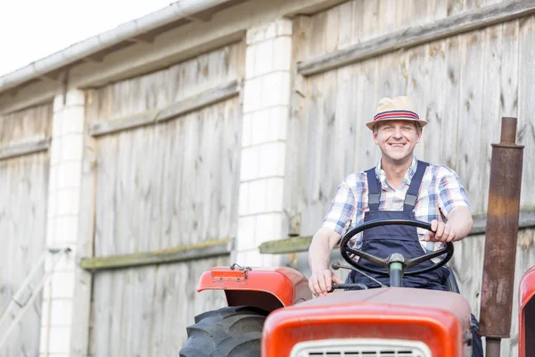 Selbstbewusst Lächelnder Landwirt Fährt Traktor Gegen Scheune Auf Bauernhof — Stockfoto