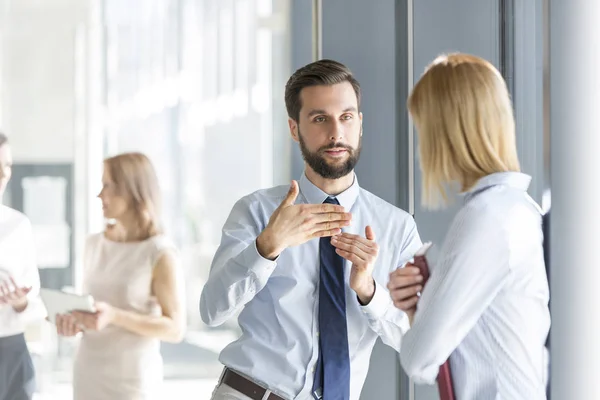 Serious Professional Explaining Colleague Office Corridor — Stock Photo, Image