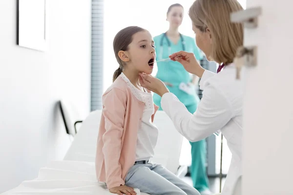 病院で女の子を診察する小児科医 — ストック写真