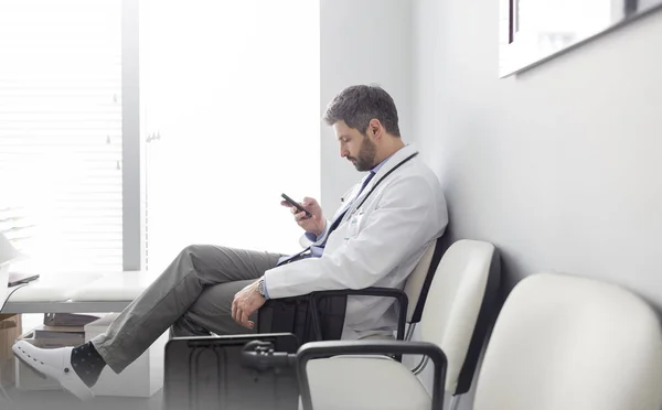 Full Length Doctor Texting Smartphone While Sitting Waiting Room Hospital — Stock Photo, Image