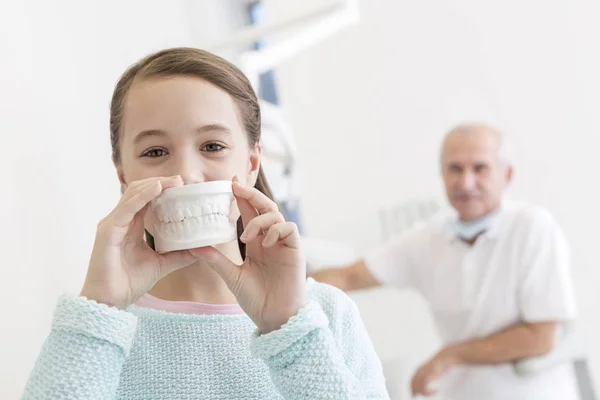 Retrato Menina Mostrando Dentaduras Contra Dentista Sentado Clínica Odontológica — Fotografia de Stock