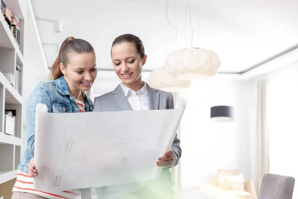 Sorridente Giovane Commessa Cliente Femminile Guardando Cianografia Appartamento — Foto Stock