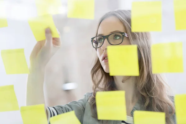 Joven Mujer Negocios Pegando Nota Pared Vidrio — Foto de Stock