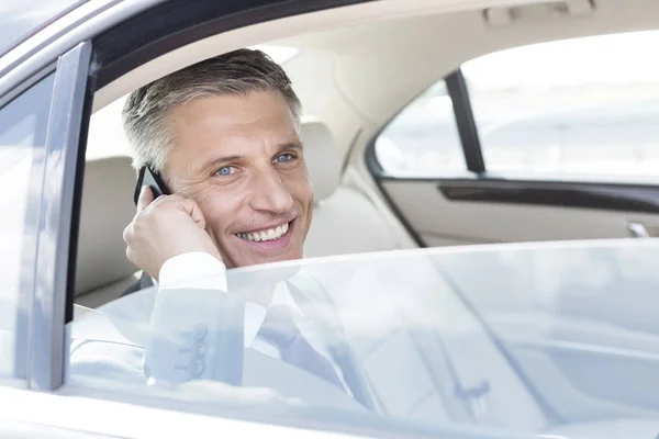 Hombre Negocios Sonriente Hablando Teléfono Inteligente Mientras Mira Través Ventana —  Fotos de Stock