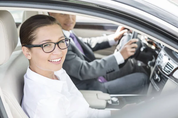 微笑的女商人的画像坐与同事坐在汽车 — 图库照片