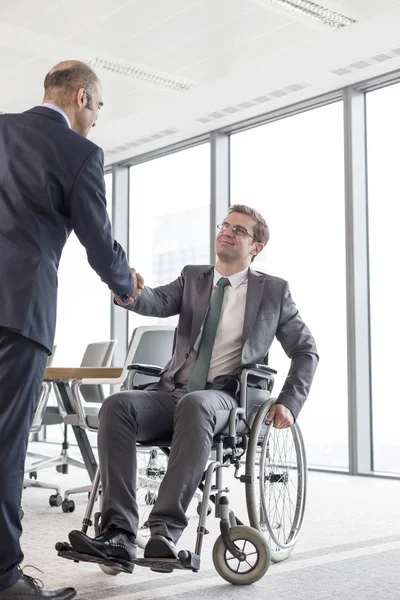 商人在办公室会议室与微笑的残疾同事握手 — 图库照片