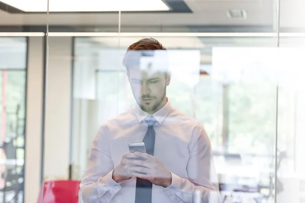 Jungunternehmer Mit Smartphone Durch Fenster Büro Gesehen — Stockfoto