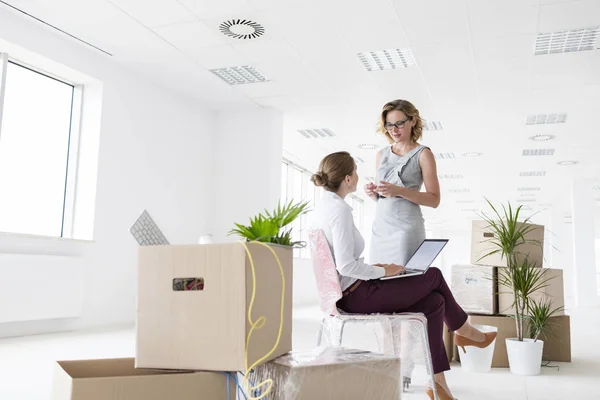 Businesswomen Discussing Amidst Cardboard Boxes New Office — Stock Photo, Image