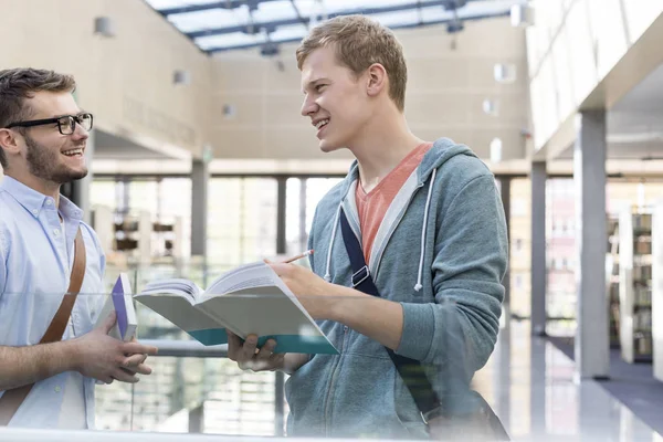 Amici Felici Che Parlano Mentre Leggono Libri Nel Corridoio Universitario — Foto Stock