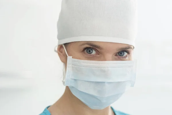 诊所戴外科口罩和帽子的女医生特写镜头 — 图库照片