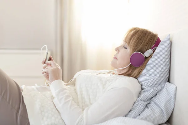 Vista Lateral Mujer Madura Escuchando Música Mientras Está Acostada Cama —  Fotos de Stock