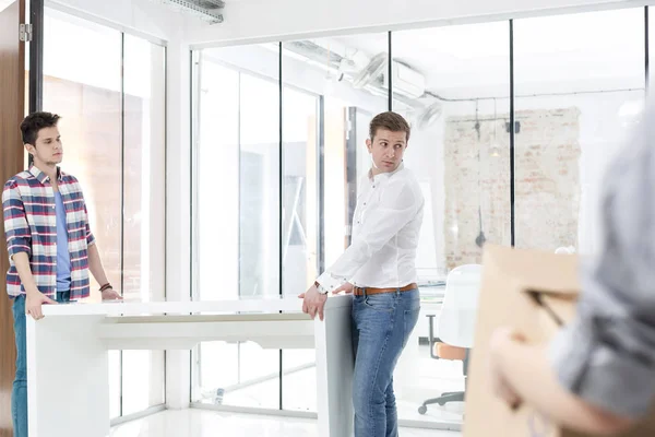 Kreative Kollegen Tragen Schreibtisch Beim Büroaufbau — Stockfoto