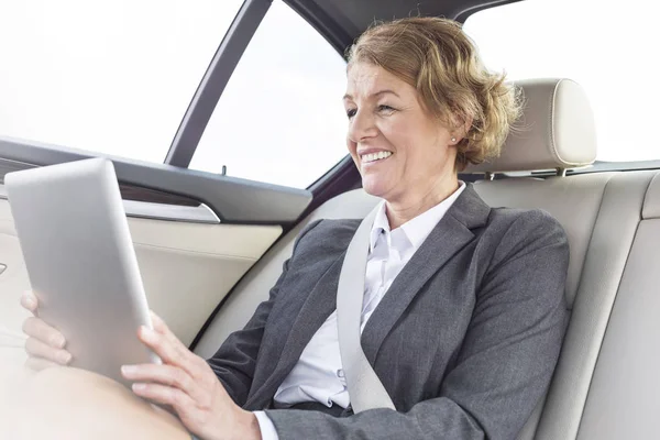汽车用数字平板电脑微笑的女商人 — 图库照片