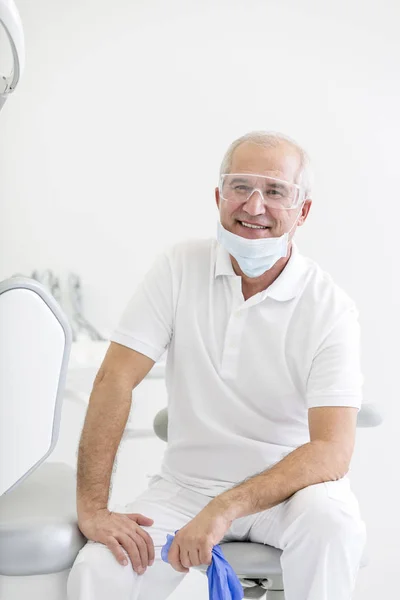 Portret Uśmiechający Się Dentysty Senior Siedzący Krześle Klinice Stomatologicznej — Zdjęcie stockowe