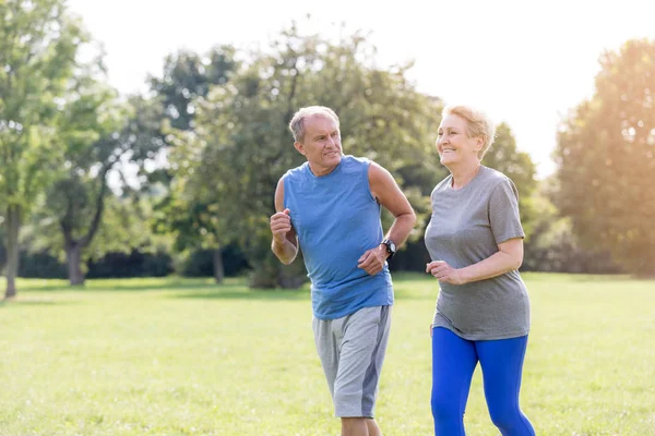 Healthy senior couple jogging in park