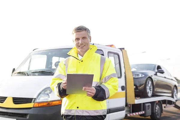 Portret Van Glimlachen Sleepwagen Bestuurder Met Klembord Tegen Hemel — Stockfoto