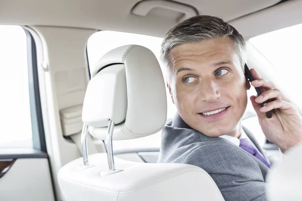 Hombre Negocios Sonriente Hablando Teléfono Inteligente Mientras Está Sentado Coche —  Fotos de Stock