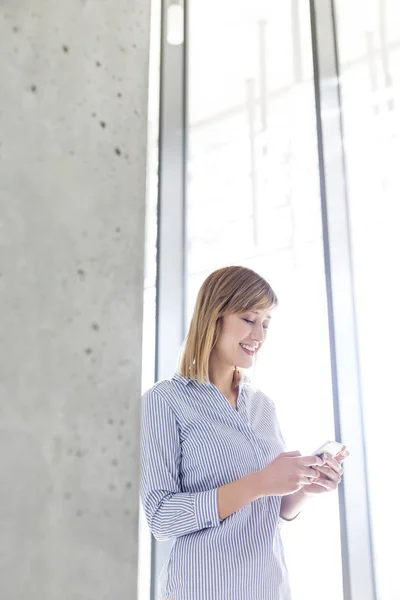 Lächelnde Geschäftsfrau Beim Sms Schreiben Handy Fenster Büro — Stockfoto