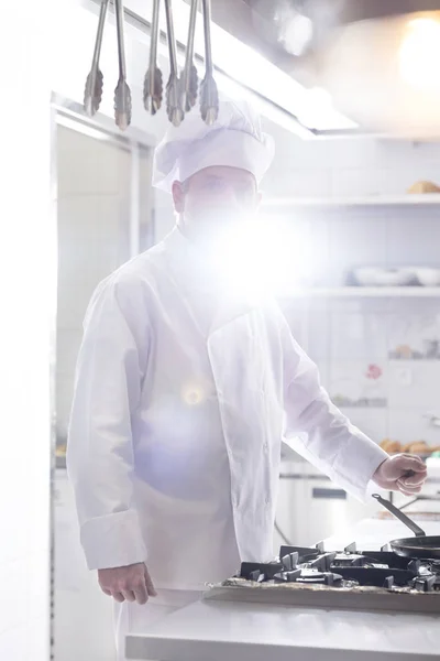 厨师站在厨房柜台在餐厅与背光背景 — 图库照片