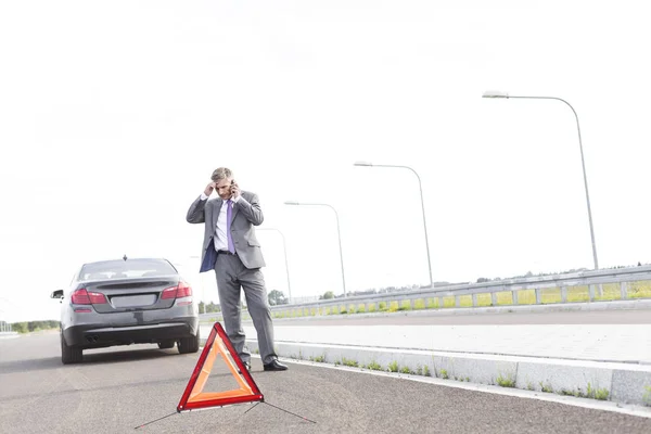 Geschäftsmann Telefoniert Stehen Mit Pannenauto Bei Warnschild Auf Straße — Stockfoto