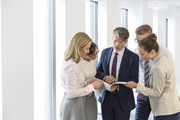 Business People Discussing Document While Standing Corridor Office — Stock Photo, Image