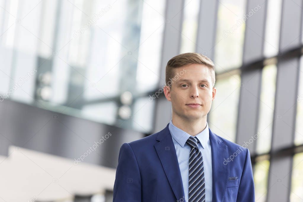 Portrait of confident young businessman standing at office