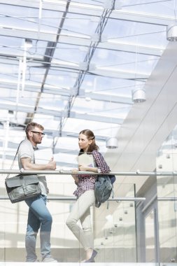 Koridorda Üniversitesi Kampüsü dururken konuşmaya genç öğrenciler