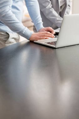 Olgun adam ve saleswoman daire laptop üzerinde tartışıyor midsection