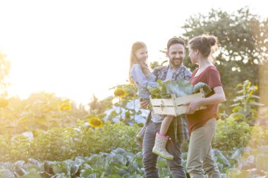 Gökyüzü karşı çiftlikte yürüyüş sebze ile aile