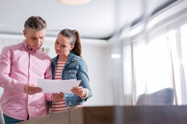 Çift dairede dururken anlaşma kağıdı okuyor.