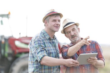 Dijital tablet çiftliğinde bir şey tartışırken ile kendine güvenen çiftçiler