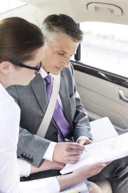 Meslektaşım arabada otururken belgelerin imzalanması işadamı