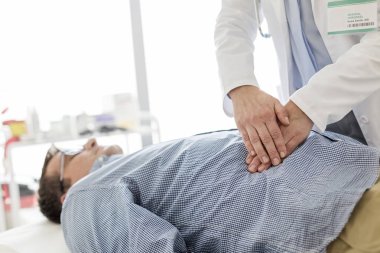 Muayene odasında hastanın midesini tedavi eden doktor