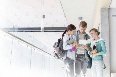 Arkadaşlar kitap Üniversitesi'nde koridorda duran üzerinde tartışıyor