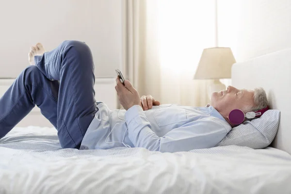 Zijaanzicht Van Man Luisteren Muziek Terwijl Liggend Bed Thuis — Stockfoto