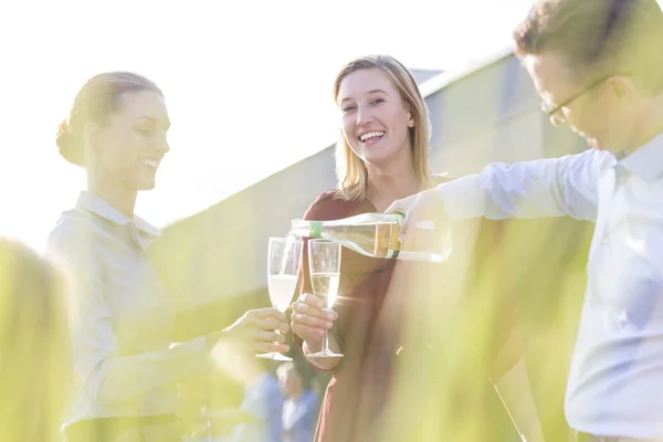 Hombre Negocios Sonriente Sirviendo Vino Sus Colegas Fiesta Azotea —  Fotos de Stock