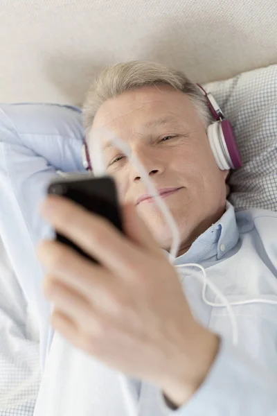 Mogen Man Tittar Smartphone Liggande Sängen Hemma — Stockfoto